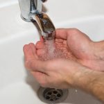 Close-up of hands being washed under running water